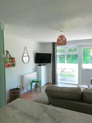 a living room with a couch and a tv at Cornwall family friendly villa with free use of Pool, soft play, mini golf, tennis, gym, fitness classes, sauna and ice baths in Newquay