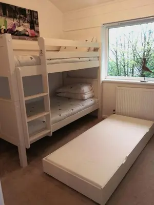 a bedroom with a bunk bed and a window at Cornwall family friendly villa with free use of Pool, soft play, mini golf, tennis, gym, fitness classes, sauna and ice baths in Newquay