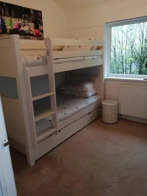 a bunk bed in a room with a window at Cornwall family friendly villa with free use of Pool, soft play, mini golf, tennis, gym, fitness classes, sauna and ice baths in Newquay