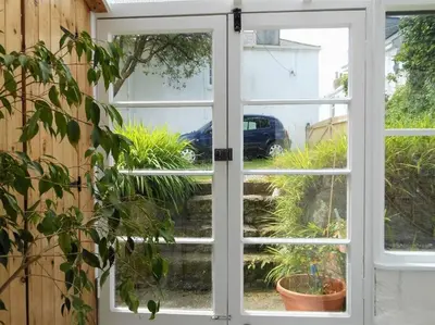 an open door looking out at a garden at Lovely cottage with private garden in Penryn