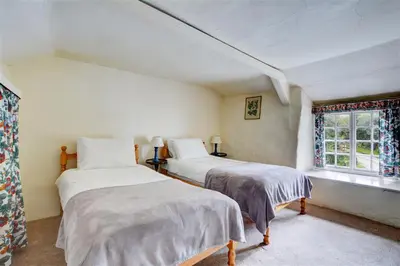 two beds in a white room with a window at 3 Bed in Lostwithiel oc-cmerl in Saint Winnow