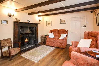 a living room with a fireplace and furniture at 3 Bed in Lostwithiel oc-cmerl in Saint Winnow