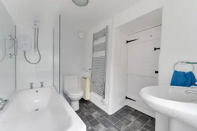 a white bathroom with a tub and a sink and a toilet at 3 Bed in Lostwithiel oc-cmerl in Saint Winnow