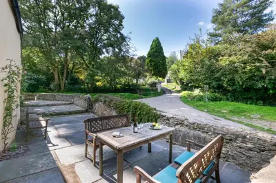 a patio with a wooden table and two benches at 3 Bed in Lostwithiel oc-cmerl in Saint Winnow