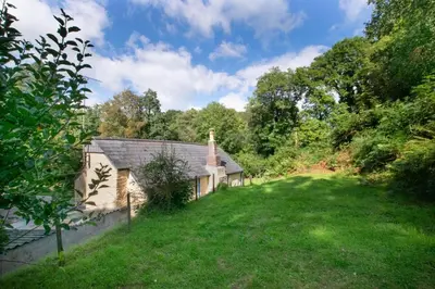 an old house with a grassy yard next to a church at 3 Bed in Lostwithiel oc-cmerl in Saint Winnow