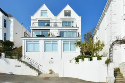 a white house with stairs in front of it at 1 Bed in Fowey oc-cmoonr in Fowey