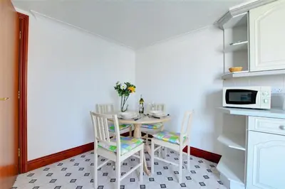 a kitchen with a table and chairs and a microwave at 1 Bed in Fowey oc-cmoonr in Fowey