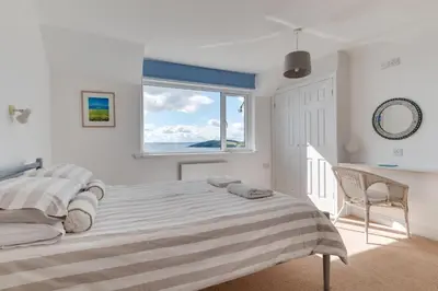 a white bedroom with a large bed and a window at 4 Bed in Fowey oc-cridg2 in Fowey