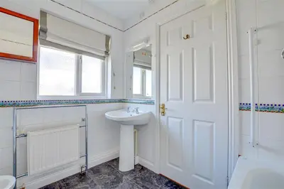 a white bathroom with a sink and a mirror at 4 Bed in Fowey oc-cridg2 in Fowey