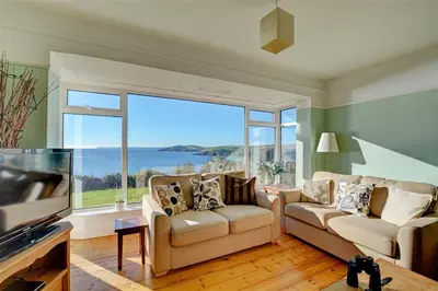 a living room with two couches and a large window at 4 Bed in Polruan oc-csclif in Fowey