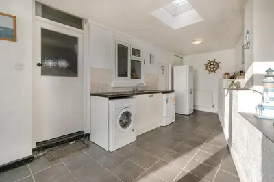 a kitchen with a washing machine and a refrigerator at 4 Bed in Polruan oc-csclif in Fowey