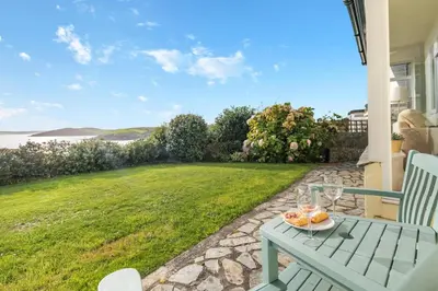 a table with a plate of food on a patio at 4 Bed in Polruan oc-csclif in Fowey