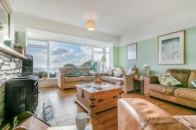 a living room with a couch and a fireplace at 4 Bed in Polruan oc-csclif in Fowey