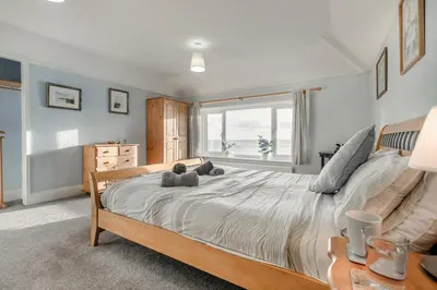 a bedroom with a large bed with a teddy bear on it at 4 Bed in Polruan oc-csclif in Fowey