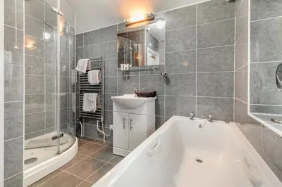 a bathroom with a bath tub and a sink at 4 Bed in Polruan oc-csclif in Fowey