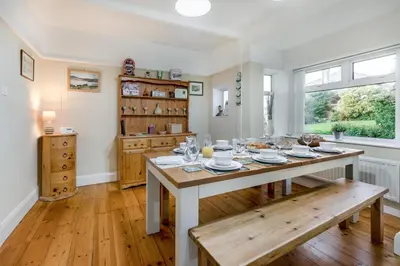 a dining room with a table and a bench at 4 Bed in Polruan oc-csclif in Fowey