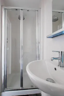 a white bathroom with a shower and a sink at 3 Bed in Fowey oc-cstepa in Fowey