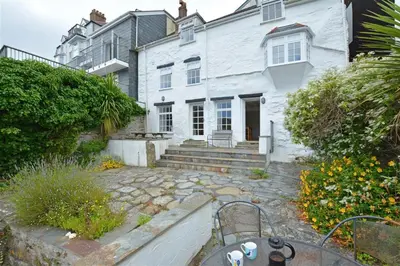 a white house with a stone patio in front of it at 3 Bed in Fowey oc-cstepa in Fowey