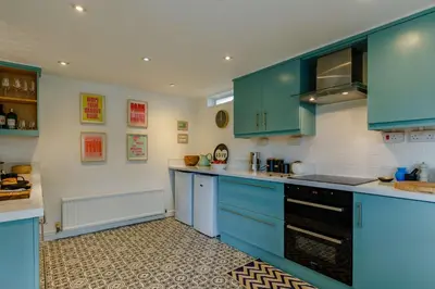 a kitchen with blue cabinets and a stove at 4 Bed in Mawgan Porth oc-d26830 in Mawgan Porth