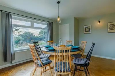 a dining room with a table and chairs and a window at 4 Bed in Mawgan Porth oc-d26830 in Mawgan Porth
