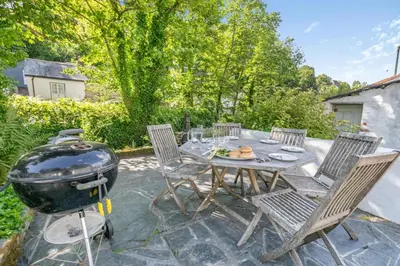 a patio with a grill and a table and chairs at 3 Bed in Helford oc-dowrpe in Helford