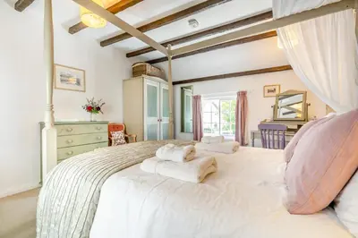 a bedroom with a large white bed with two towels on it at 3 Bed in Helford oc-dowrpe in Helford