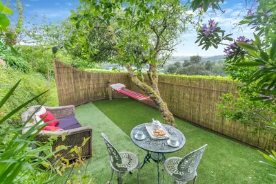 a garden with a table and chairs and a tree at 4 Bed in Pentewan oc-edghil in Pentewan
