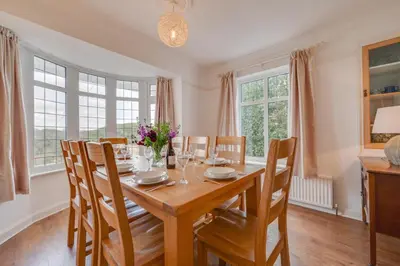 a dining room with a wooden table and chairs at 4 Bed in Pentewan oc-edghil in Pentewan