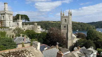an old castle with a clock tower in a town at 2 Bed in Fowey oc-forty in Fowey