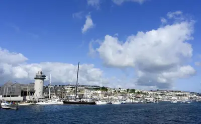 a group of boats in a harbor with a lighthouse at 2 Bed in Redruth oc-gbells in Porkellis