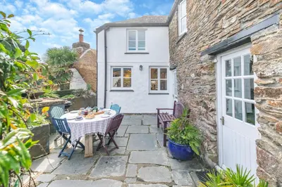 a patio in a cottage with a table and chairs at 3 Bed in Helford oc-hccott in Helford