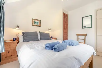 a bedroom with a white bed with blue towels on it at 3 Bed in Helford oc-hccott in Helford
