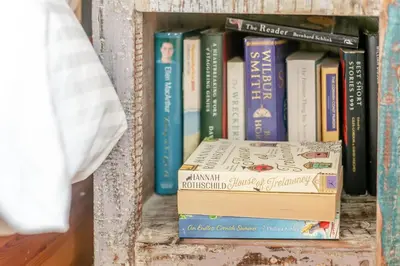 a stack of books sitting on a shelf at 3 Bed in Helford oc-hccott in Helford