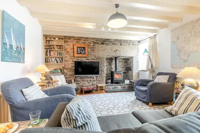 a living room with blue chairs and a fireplace at 3 Bed in Helford oc-hccott in Helford