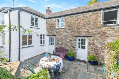 a property with a patio and a table in front of a building at 3 Bed in Helford oc-hccott in Helford