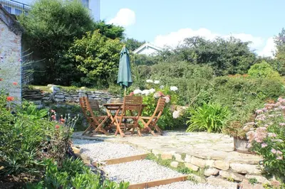 a table and chairs and an umbrella in a garden at 3 Bed in Helford oc-hcmimo in Helford