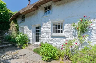 a white house with flowers in front of it at 3 Bed in Helford oc-hcmimo in Helford