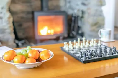 a bowl of fruit sitting next to a chess board at 2 Bed in Helford oc-hcpopi in Helford