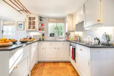 a kitchen with white cabinets and black counter tops at 2 Bed in Helford oc-hcpopi in Helford