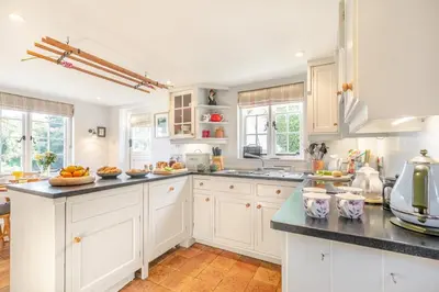 a kitchen with white cabinets and black counter tops at 2 Bed in Helford oc-hcpopi in Helford