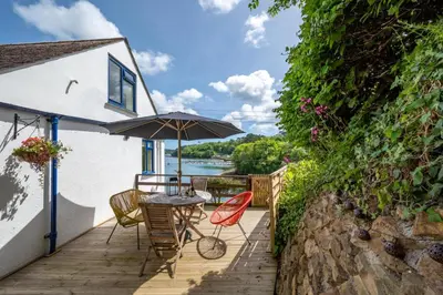 a patio with a table and chairs and an umbrella at 2 Bed in Helford oc-hcview in Helford