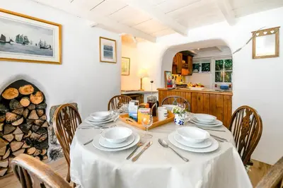 a dining room with a table and a kitchen at 3 Bed in Helford oc-hcwedn in Helford