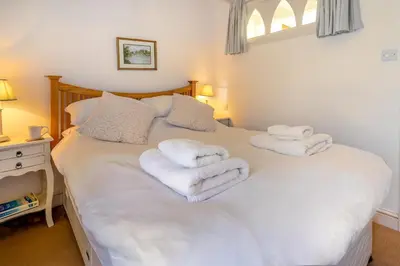 a bedroom with a white bed with towels on it at 3 Bed in Helford oc-hcwedn in Helford