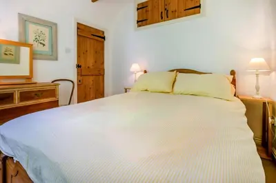 a large white bed in a bedroom with two lamps at 3 Bed in Helford oc-hcwedn in Helford