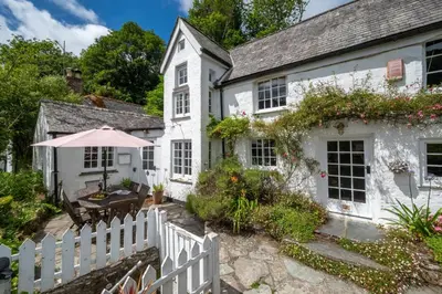 a white house with a white picket fence at 3 Bed in Helford oc-hcwell in Helford