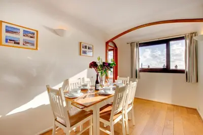 a dining room with a wooden table and chairs at 3 Bed in Porthleven oc-ingnoo in Porthleven
