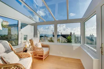 a room with a bunch of windows and chairs at 3 Bed in Porthleven oc-ingnoo in Porthleven