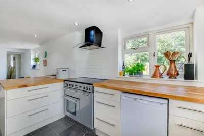 a kitchen with white cabinets and a wooden counter top at 2 Bed in Breage oc-jobcot in Breage