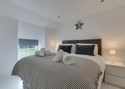a bedroom with a large bed with towels on it at 2 Bed in Breage oc-jobcot in Breage