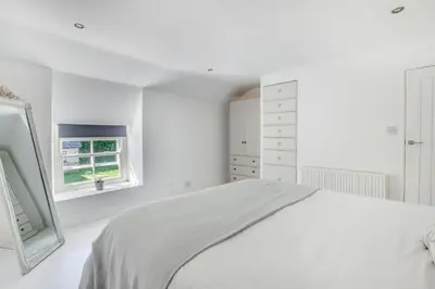 a white bedroom with a bed and a window at 2 Bed in Breage oc-jobcot in Breage